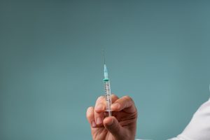 Arzt hält Spritze mit Betäubungsmittel